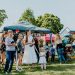 A lively outdoor gathering with families enjoying balloons and a sunny day.